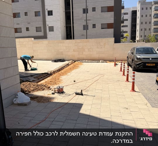אדם עובד בחוץ ליד בניין עם כלי עבודה